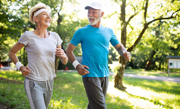 Beautiful mature couple jogging in nature living healthy